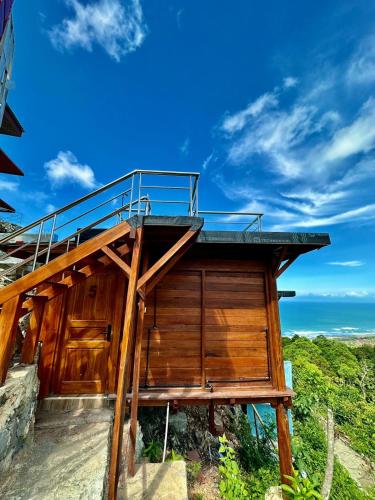 a building with a balcony on top of it at Glamping Omah Kayu at Watu Paris Jogja in Girijati