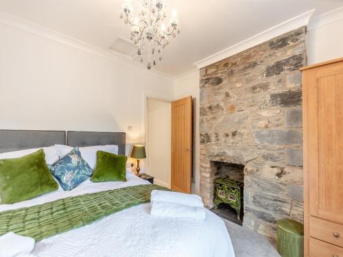 a bedroom with a bed and a stone wall at Glanllyn in Betws-y-coed