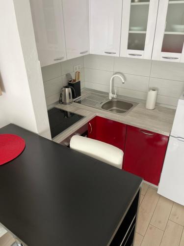 a kitchen with white cabinets and a black counter top at Elena in Rab