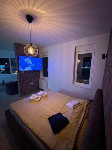 a bedroom with a large bed with towels on it at Apartman North in Mladenovac