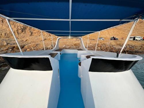 ein Boot mit blauen und weißen Sitzen auf dem Wasser in der Unterkunft Morgana in Ain Suchna