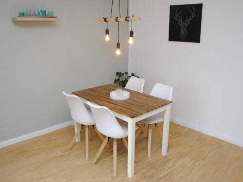 a dining room table with white chairs around it at Ferienwohnung Hof Konietzke in Thale