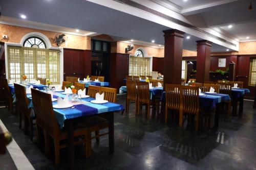 ein Esszimmer mit blauen Tischen und Stühlen in der Unterkunft Kottavathil Hotel in Tripunittura