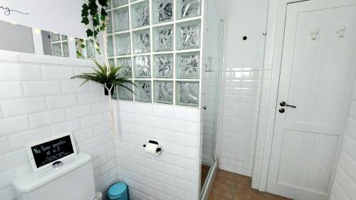 a white bathroom with a shower and a toilet at Casa D’Amelia in Ojén