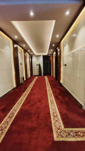 a hallway with a red carpet and a long hallway with a christmas tree at Al Masem Serviced Apartments - Al Olaya - Exit 5 in Riyadh