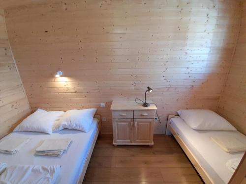 um quarto com duas camas e uma mesa num camarote em Domki Valhalla Polna 8a Chłopy Sarbinowo em Chłopy