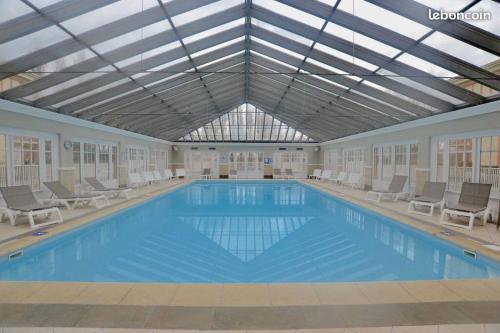 une grande piscine avec des chaises et un plafond dans l'établissement Appt 4 pers-2 CHB-2 SDB-Piscine-Linge inclus-Literies faites à l'arrivée inclus-Parking, à Le Touquet-Paris-Plage