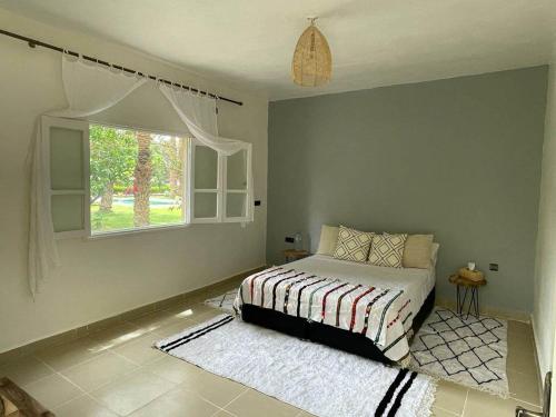 a bedroom with a bed and a window at Maison d H&ocirc;te Ighrem in Goulmima