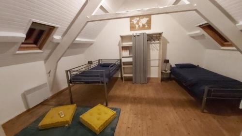 Pokój na poddaszu z 2 łóżkami i stołem w obiekcie Gite St Pol de Léon 4 chambres, draps fournis w mieście Saint-Pol-de-Léon