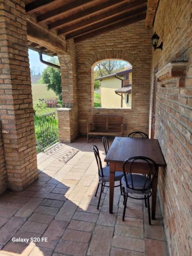 an outdoor patio with a wooden table and chairs at Il Castelletto di Gomo in Godiasco