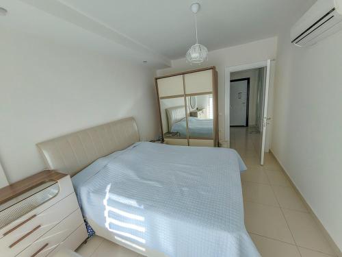 een kleine slaapkamer met een bed en een spiegel bij Aura-C10-1BR-luxury-Apt in Çamyolu
