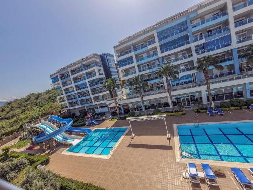 un gran edificio de apartamentos con piscina y tobogán en Aura-C10-1BR-luxury-Apt, en Çamyolu