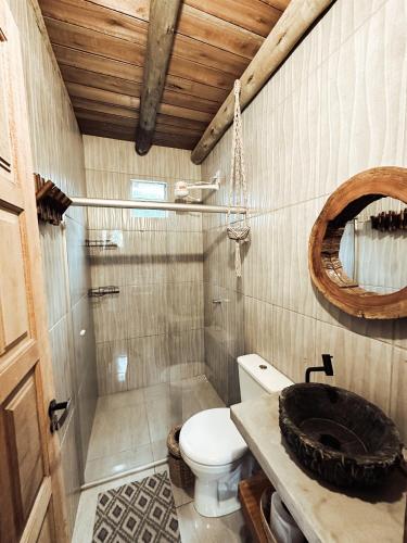 a bathroom with a toilet and a shower and a sink at CASA MUNDI in Caraíva