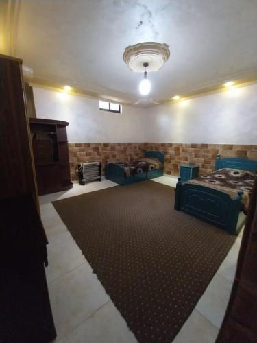 Habitación grande con 2 camas y alfombra. en Four session apartments jarash, en Jerash