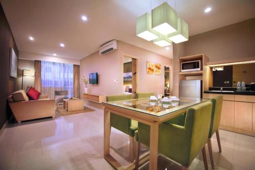 a kitchen and living room with a table and chairs at eL Hotel Jakarta in Jakarta