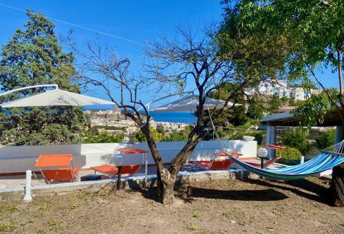 a hammock and chairs in a yard with a tree at Villa la Milanina in Lipari