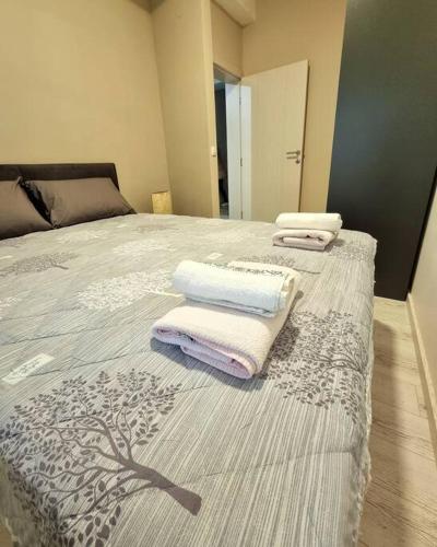 a bedroom with a bed with towels on it at Apartman Rojal Vranje in Vranje