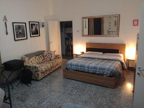 1 dormitorio con cama, sofá y espejo en Miky M House B&B, en Cagliari
