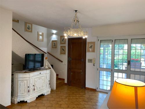 a living room with a television and a chandelier at Villino a 300 mt dal mare - A solo un'ora di treno dal centro di Roma in Anzio