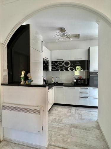 a kitchen with white cabinets and a chandelier at Apartment Kiki in Kotor