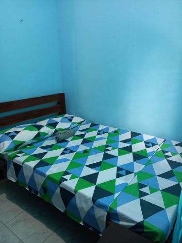 a bed with a colorful comforter in a room at CBHaus in El Nido