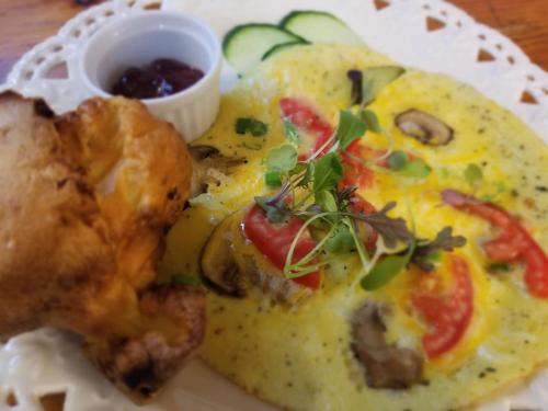 a plate of omelet with meat and vegetables and a sauce at Timbercliffe Cottage Inn in Camden
