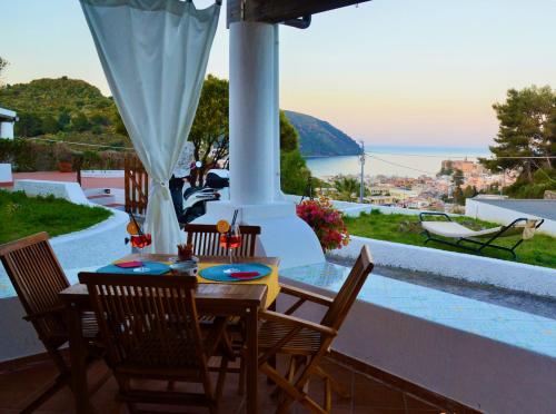 a table and chairs on a balcony with a view of the ocean at Villa la Milanina in Lipari