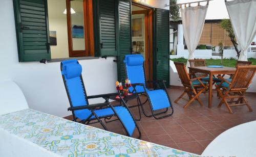 a patio with blue chairs and a table and a table at Villa la Milanina in Lipari