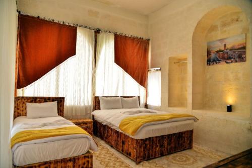 1 dormitorio con 2 camas y ventana en karagül otel en Sanlıurfa