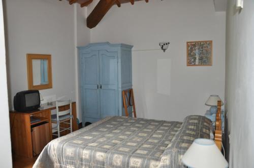 a bedroom with a bed and a blue cabinet at Villa Acquafredda in Orvieto