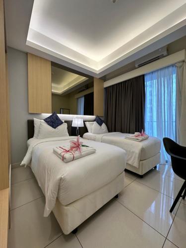 a hotel room with two beds with pink bows on them at Genting @ The MOST by NextGen in Genting Highlands