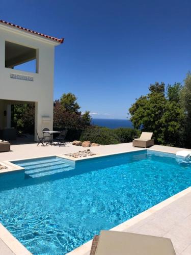 - une piscine en face d'une maison dans l'établissement Kyparissia De Wandelboom, à Vrísai