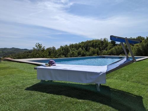 a pool with a table in the middle of a field at B&B with pool La Montaldina Piemonte in Spigno Monferrato