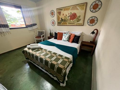 1 dormitorio con 1 cama y 1 silla en Pousada Recanto dos Leões, en Pirenópolis
