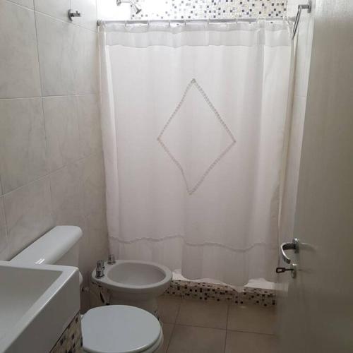 ein Badezimmer mit einem weißen Duschvorhang und einem WC in der Unterkunft Dpto. San Luis Zona Shopping/centro in San Luis