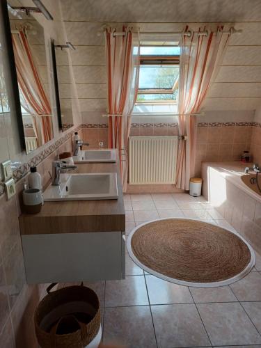 uma casa de banho com 2 lavatórios, uma banheira e um chuveiro em Kerniguez 3 em Carhaix-Plouguer