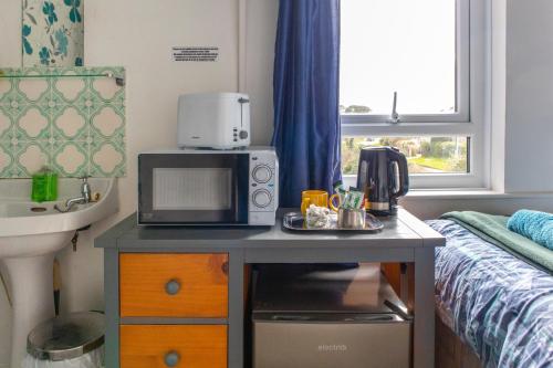 uma cozinha com um micro-ondas numa mesa num quarto em Penkerris em St. Agnes