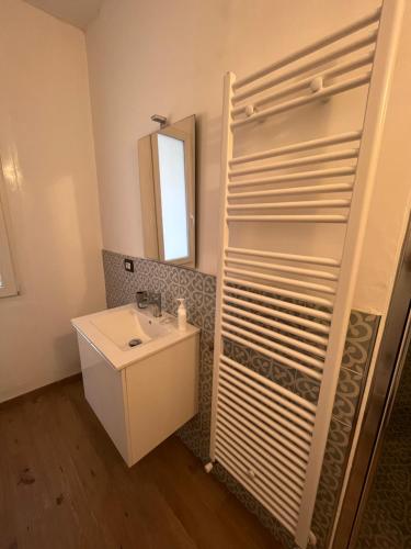 een badkamer met een wastafel en een spiegel bij Le stanze di Alicam in Arona