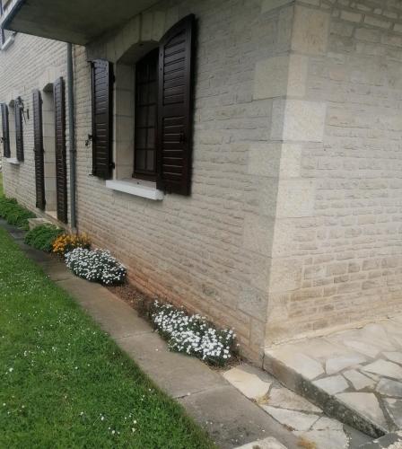 een stenen huis met bloemen aan de zijkant bij Gaillarde in Brive-la-Gaillarde