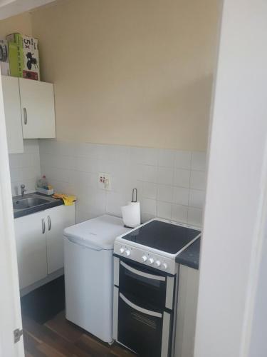 a small kitchen with a sink and a stove at Tollcross Near Glasgow City Centre in Glasgow