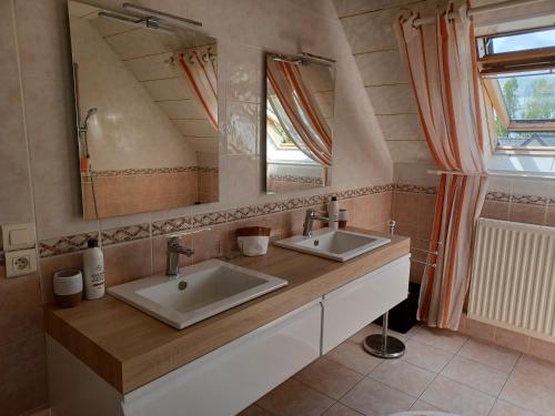 uma casa de banho com 2 lavatórios e um espelho grande em Kerniguez 3 em Carhaix-Plouguer