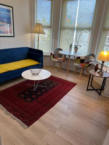 a living room with a blue couch and a table at double bedroom close to common park & city centre in Southampton