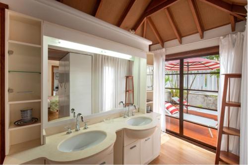 a bathroom with two sinks and a large mirror at The Gatehouse in Saint James