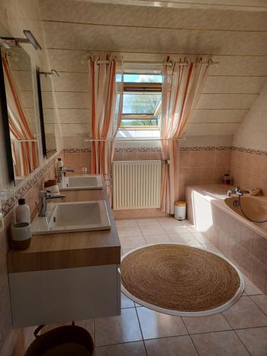 uma casa de banho com 2 lavatórios e uma banheira em Kerniguez 3 em Carhaix-Plouguer