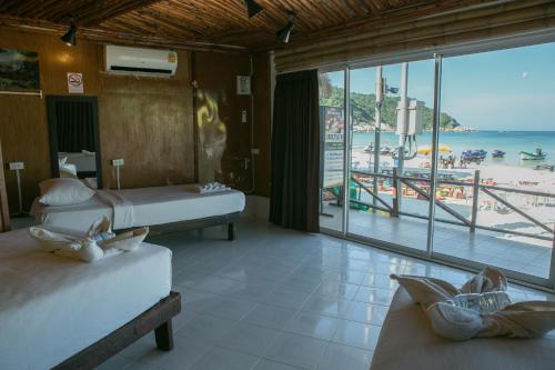 a room with two beds and a view of the beach at Haadrin Resort in Haad Rin