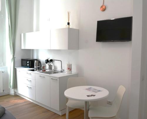 uma pequena cozinha branca com uma pequena mesa e uma pequena mesa branca e uma cozinha em Orti House Apartments - total renovation on Apr 2023 em Milão