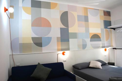 uma sala de estar com um sofá e uma parede colorida em Orti House Apartments - total renovation on Apr 2023 em Milão