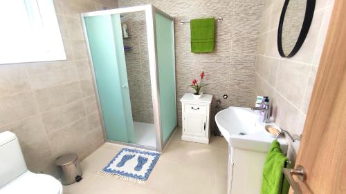 ein Bad mit einem Waschbecken und einem Spiegel in der Unterkunft Fun Guest House with Pool near Troodos in Perapedhi