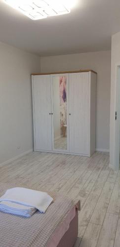 a white room with a bed and some cabinets at Dream town Apartaments біля залізничного вокзалу in Luts'k