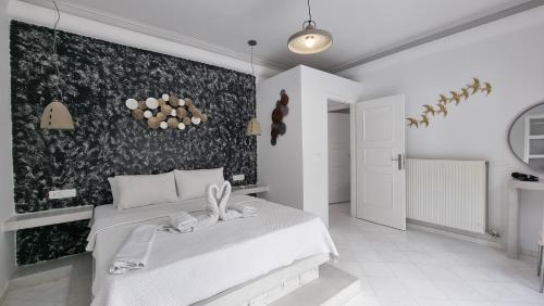 a bedroom with a white bed and a black and white wall at 3 Bedroom House included free car rental in Perissa